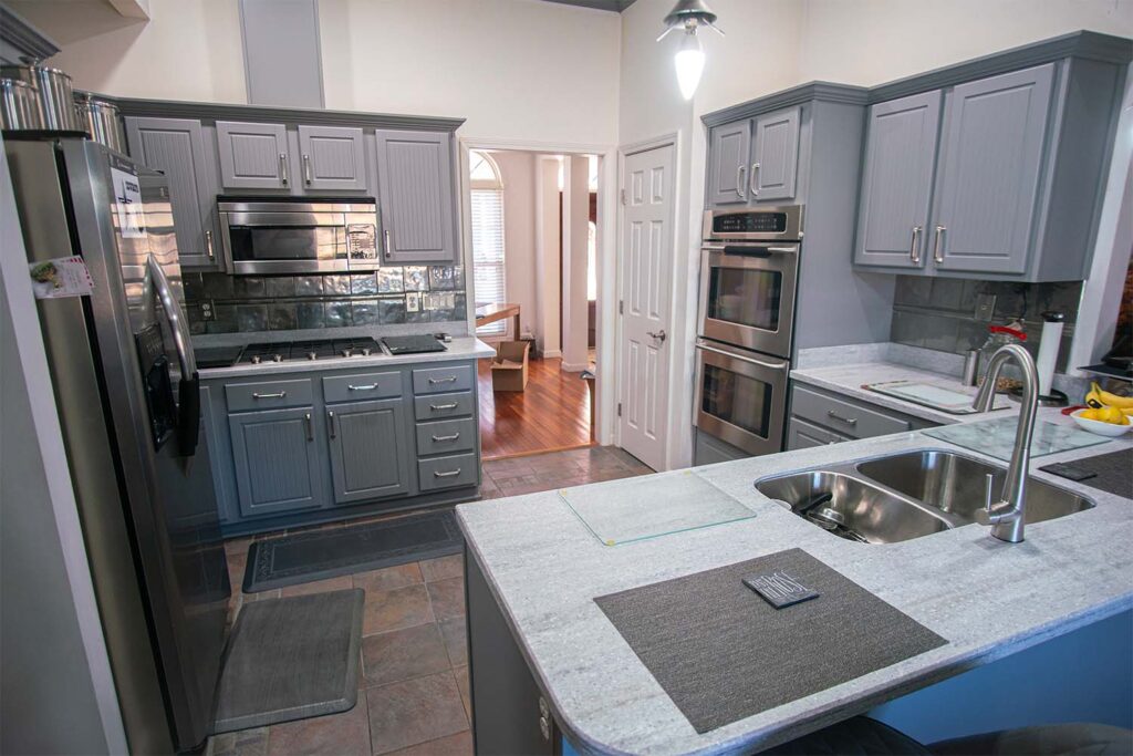 Refaced kitchen with Victory style doors and drawer fronts in dust grey after cabinet refacing.