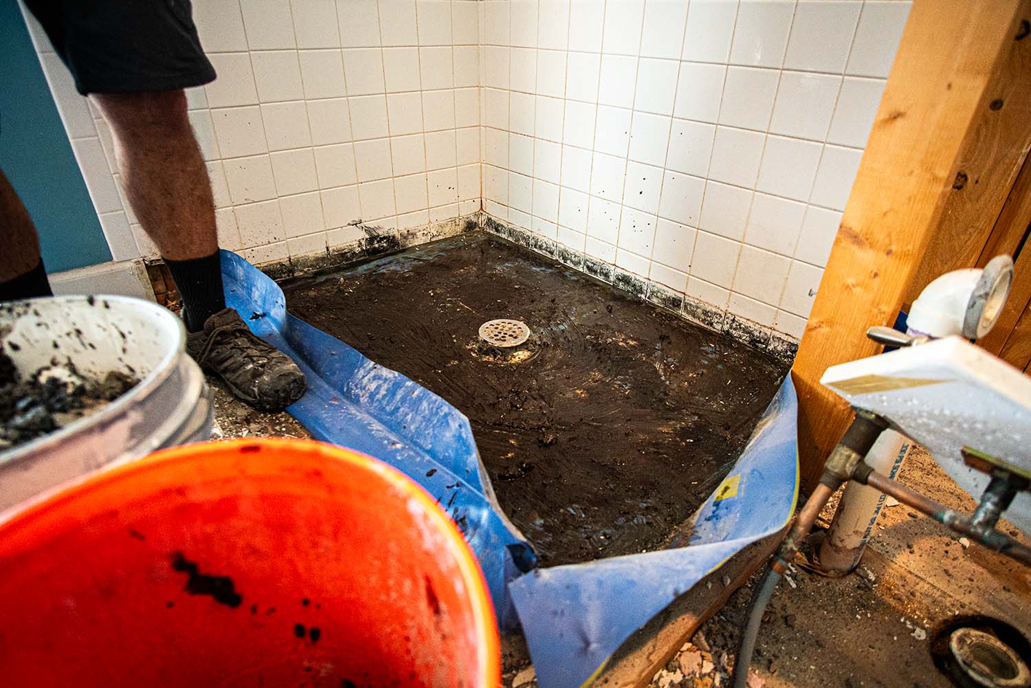 In-progress image showing the grime and mold under the old tile during a shower replacement.