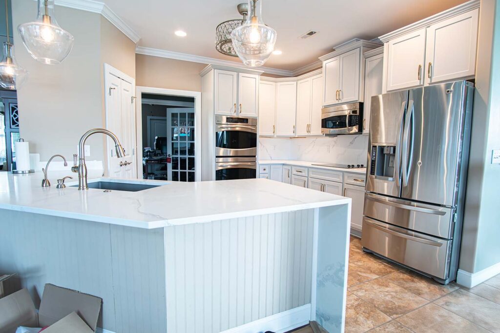 After image of a kitchen showcasing the entire space with autumn style doors in fashion grey and quartz Calcatta Capri countertops