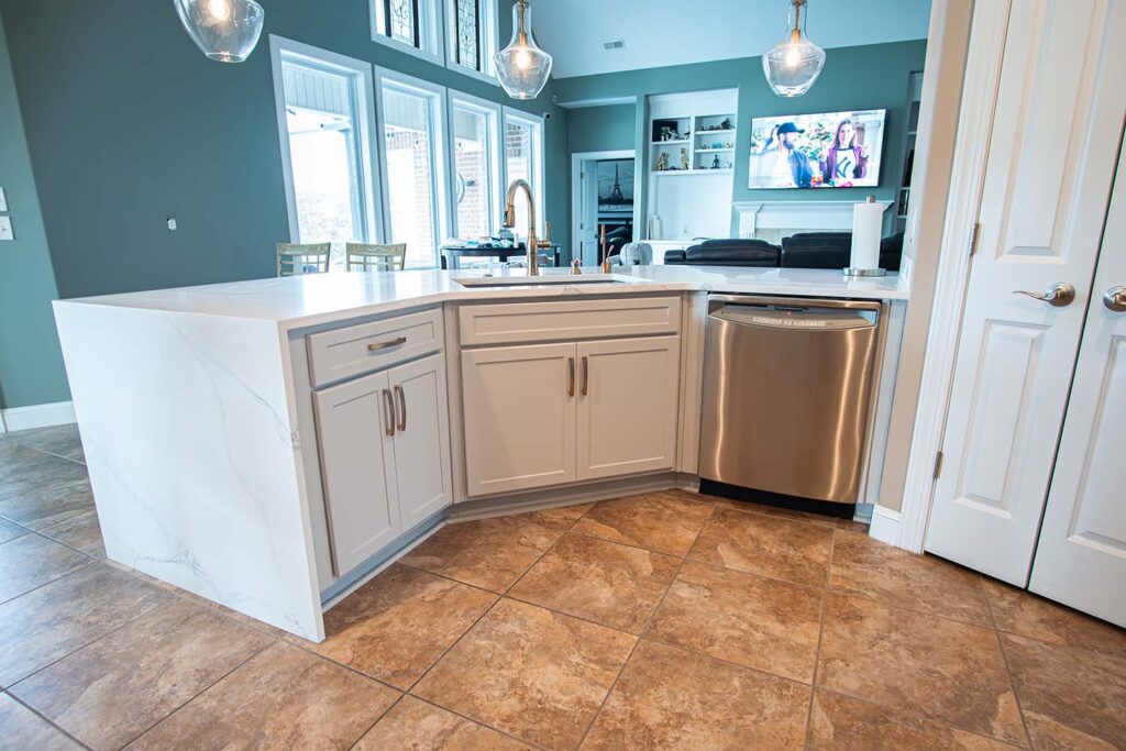 After image of a kitchen showcasing the sink area with autumn style doors in fashion grey and quartz Calcatta Capri waterfall countertops