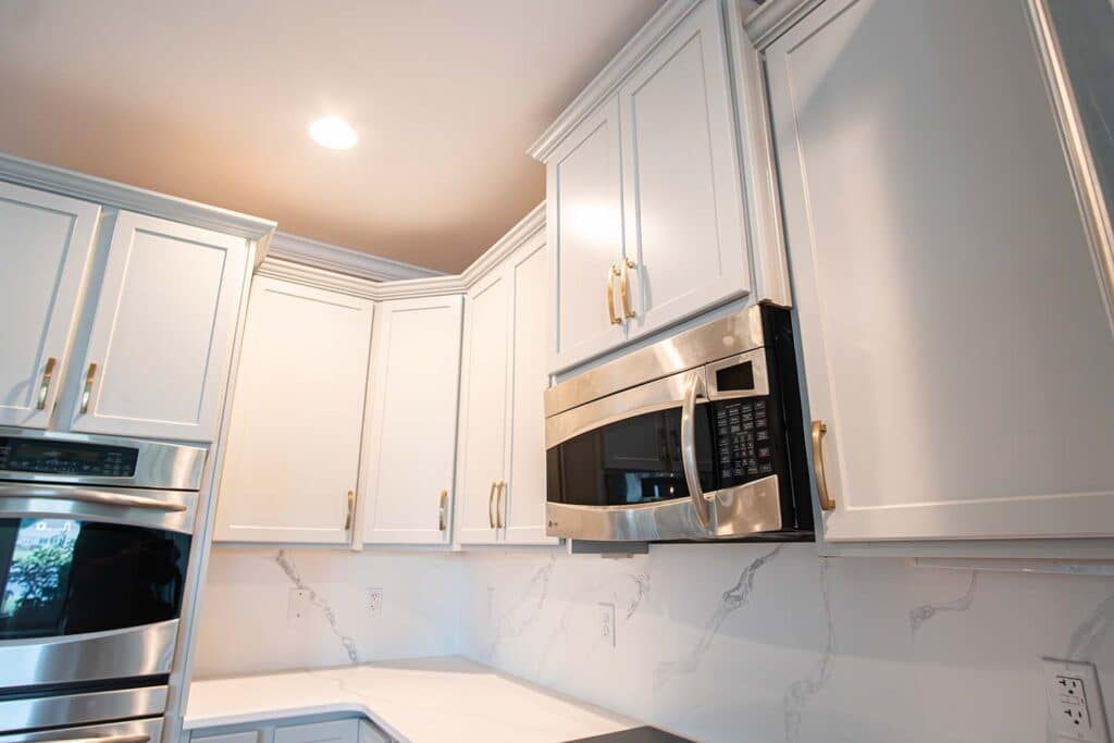 After image of a kitchen showcasing the microwave area with autumn style doors in fashion grey and quartz Calcatta Capri countertops