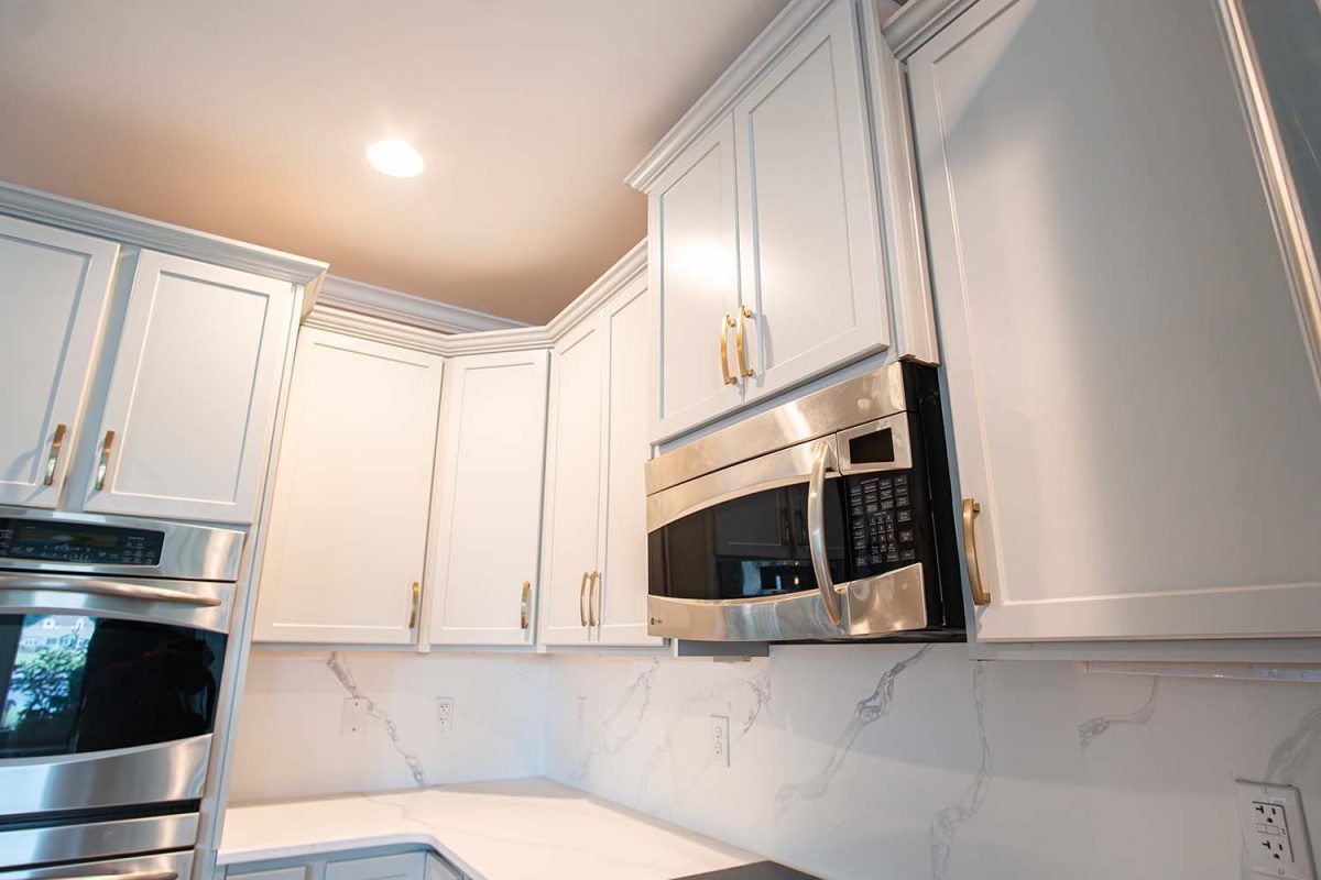 After image of a kitchen showcasing the microwave area with autumn style doors in fashion grey and quartz Calcatta Capri countertops